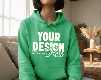 May include: A green hoodie with the text "YOUR DESIGN Here" in white. The hoodie has a drawstring hood and a front pocket. The words "HIGH-QUALITY MOCKUPS" are below the words "YOUR DESIGN".