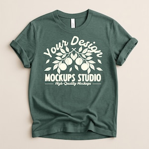 May include: A dark teal t-shirt with rolled-up sleeves. The shirt features a white graphic design with the text "Your Design" above a branch with fruit and the words "Mockups Studio High-Quality Mockups" below.