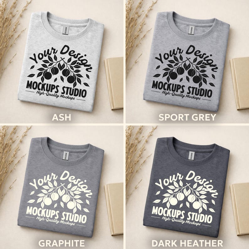 May include: Four folded t-shirts in ash, sport grey, graphite, and dark heather colors. Each shirt features a white graphic with the text "Your Design MOCKUPS STUDIO High-Quality Mockups".