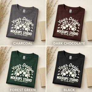 May include: Four folded t-shirts in charcoal, dark chocolate, forest green, and black. Each shirt features a white graphic with the text "Your Design MOCKUPS STUDIO High-Quality Mockups".