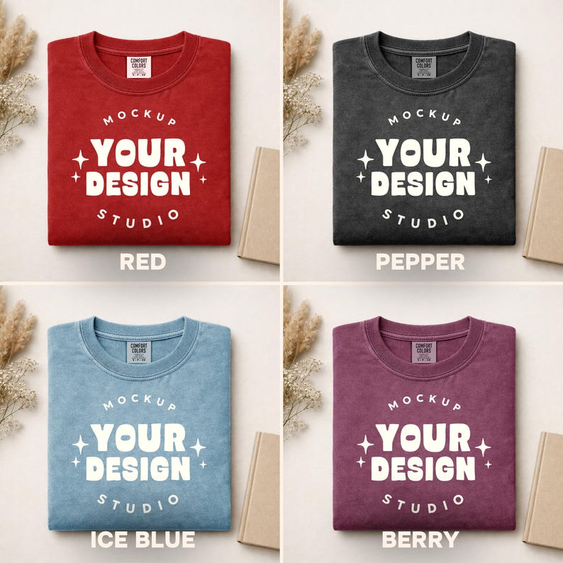 Peut inclure: Quatre t-shirts Comfort Colors de couleurs rouge, poivre, bleu glacier et baie. Chaque t-shirt affiche le texte "MOCKUP YOUR DESIGN STUDIO" en blanc. Les t-shirts sont pli&eacute;s et pr&eacute;sent&eacute;s avec des accessoires aux tons neutres.