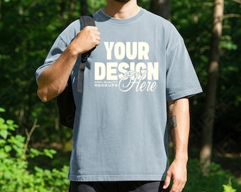 Chambray heren comfortkleuren 1717 mockup T-shirt, bos picknick lifestyle CC1717 oversized T-shirt psd jpeg mannelijk model mock-up voor canva