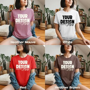May include: Four t-shirts in different colors: heather mauve, white, red, and heather brown. Each shirt has the text "YOUR DESIGN Here" in a contrasting color. The shirts are short-sleeved and appear to be made of a soft material.