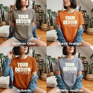 May include: Four t-shirts in different colors: Heather Olive, Burnt Orange, Autumn, and Athletic Heather. Each shirt has the text "YOUR DESIGN Here" in white. The shirts are short-sleeved and are being modeled.