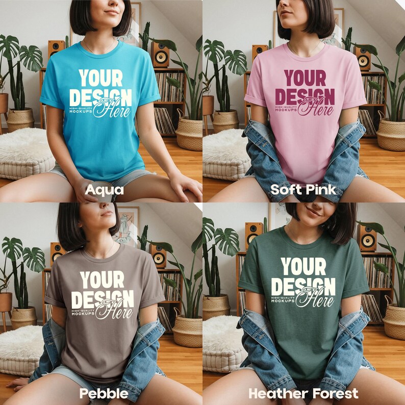 May include: Four t-shirts in aqua, soft pink, pebble, and heather forest colors. Each shirt has the text "YOUR DESIGN Here" in white. The shirts are displayed on a person sitting on a light-colored surface.