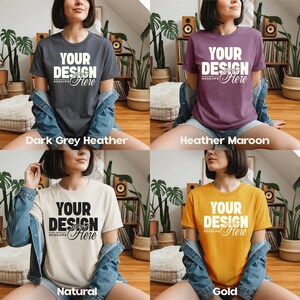 May include: Four t-shirts in different colors: dark grey heather, heather maroon, natural, and gold. Each shirt has the text "YOUR DESIGN Here" in a bold, white font. The shirts are displayed on a person wearing a denim jacket.
