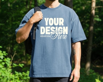 Ijsblauw heren comfort kleuren 1717 T-shirt mockup, bos picknick lifestyle CC1717 oversized T-shirt psd jpeg mannelijk model mock-up voor canva