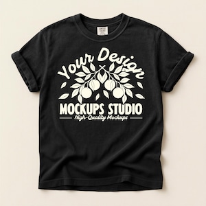 May include: Black t-shirt with rolled sleeves. The shirt features a white graphic with the text "Your Design" above a branch with fruit and the words "MOCKUPS STUDIO High-Quality Mockups" below.