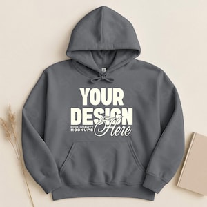 May include: A gray hoodie with a front pocket and a drawstring hood. The text "YOUR DESIGN Here" is printed on the front. The hoodie is displayed on a neutral background.