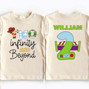 Op de afbeelding: Twee crèmekleurige kindershirts. Eén shirt heeft de tekst "Two infinity and Beyond" met een stripfiguur. Het andere heeft de naam "William" en een cartoon nummer 2.