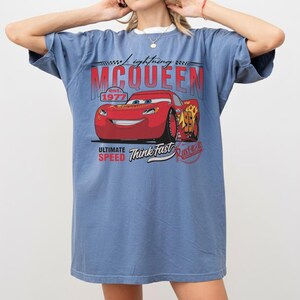 Puede incluir: Una camiseta azul con un gr&aacute;fico de Rayo McQueen de la pel&iacute;cula Cars. El dise&ntilde;o incluye el texto "Lightning McQueen" encima del coche y "Ultimate Speed Think Fast" debajo. La camiseta tiene mangas cortas.