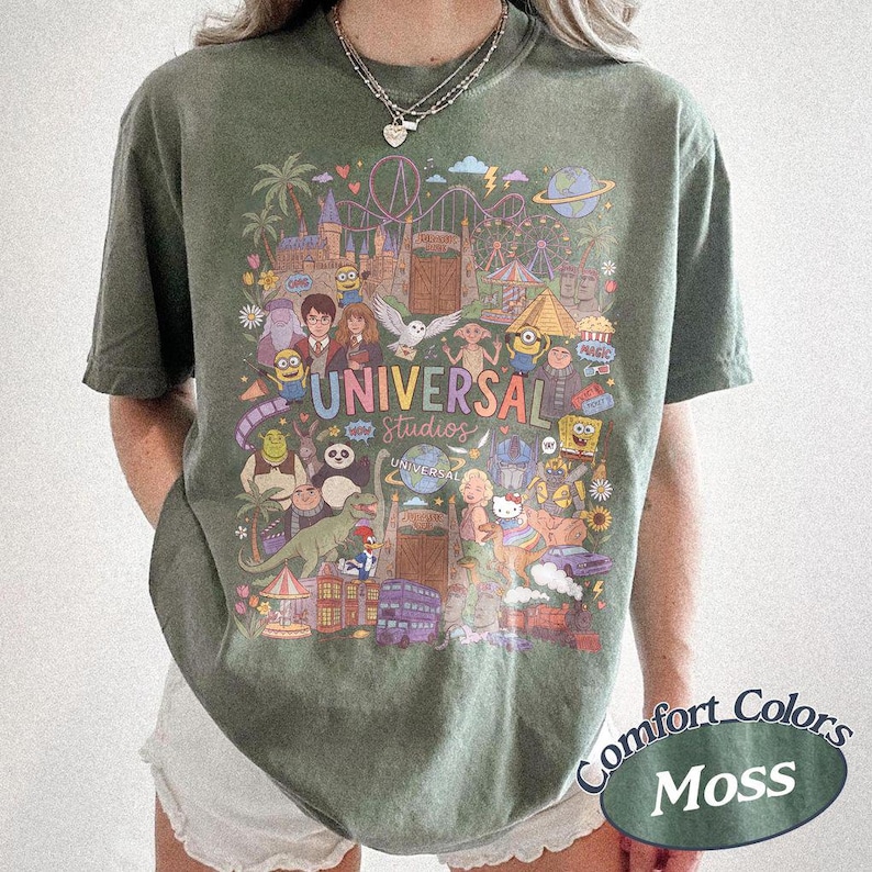 Może przedstawiać: Koszulka z kr&oacute;tkim rękawem w kolorze mchu z kolorowym nadrukiem graficznym przedstawiającym postacie i punkty orientacyjne Universal Studios. Wz&oacute;r zawiera r&oacute;żne animowane postacie, kolejkę g&oacute;rską oraz napis Universal Studios wielokolorową czcionką.