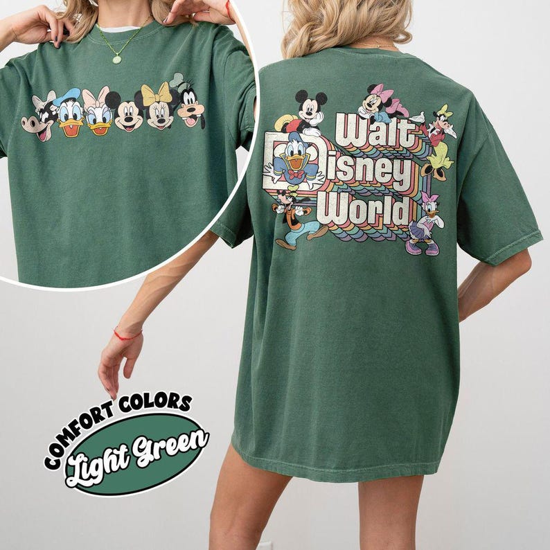 Pu&ograve; includere: T-shirt verde chiaro con personaggi Disney sul davanti e il logo Walt Disney World sul retro. La maglietta ha girocollo e maniche corte. La grafica include Topolino, Paperino e altri personaggi classici.