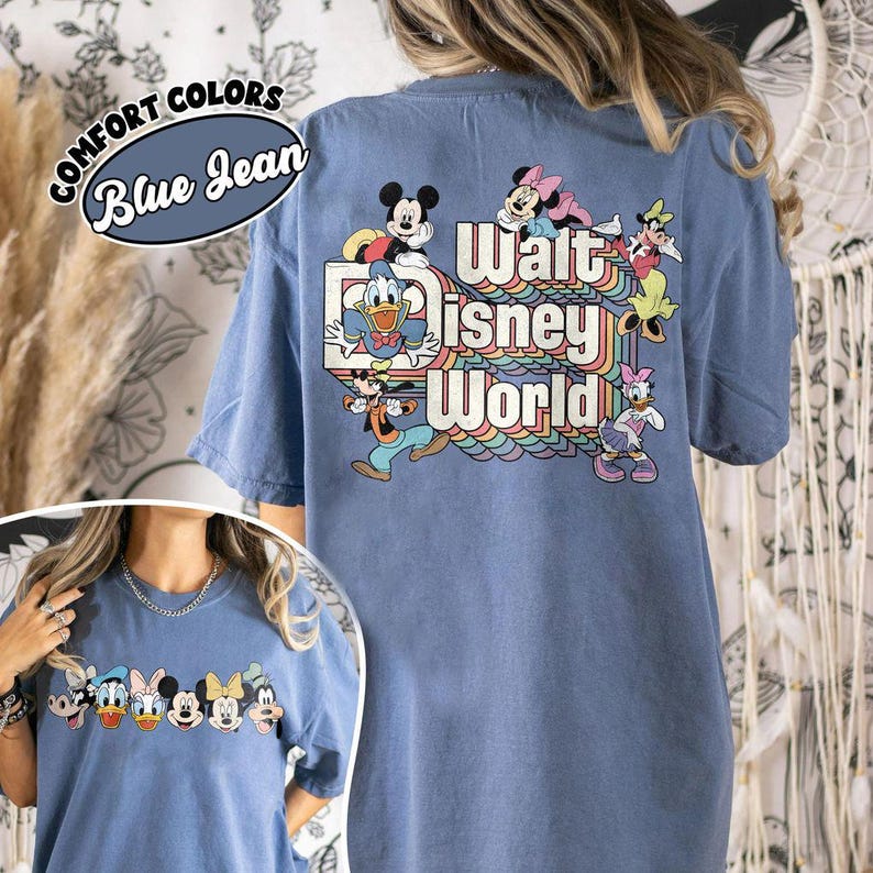 Pu&ograve; includere: T-shirt blu jeans con la scritta "Walt Disney World" e i personaggi dei cartoni animati Topolino, Minnie, Paperino, Paperina e Pippo. La maglietta ha un girocollo e maniche corte. Le parole "Comfort Colors" e "Blue Jean" sono in un design circolare.
