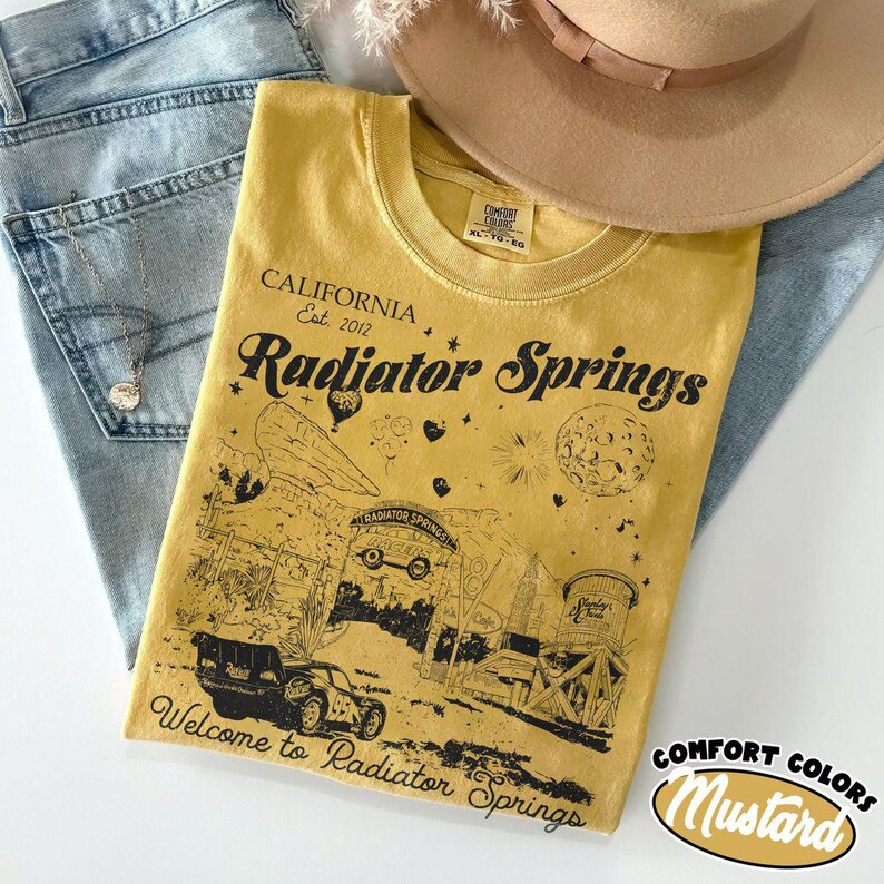 May include: A white ceramic mug with a black handle and the text "But First, Coffee" in a bold, black font. The mug is set against a neutral background, highlighting its simple design.