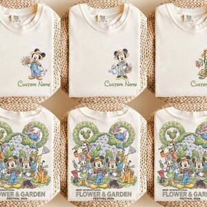 May include: Off-white t-shirts with various Disney character designs. Some shirts feature Mickey Mouse with flowers, others have Pluto or a group of characters. The text "Custom Name" and "EPCOT INTERNATIONAL FLOWER & GARDEN FESTIVAL 2026" are printed on the shirts.