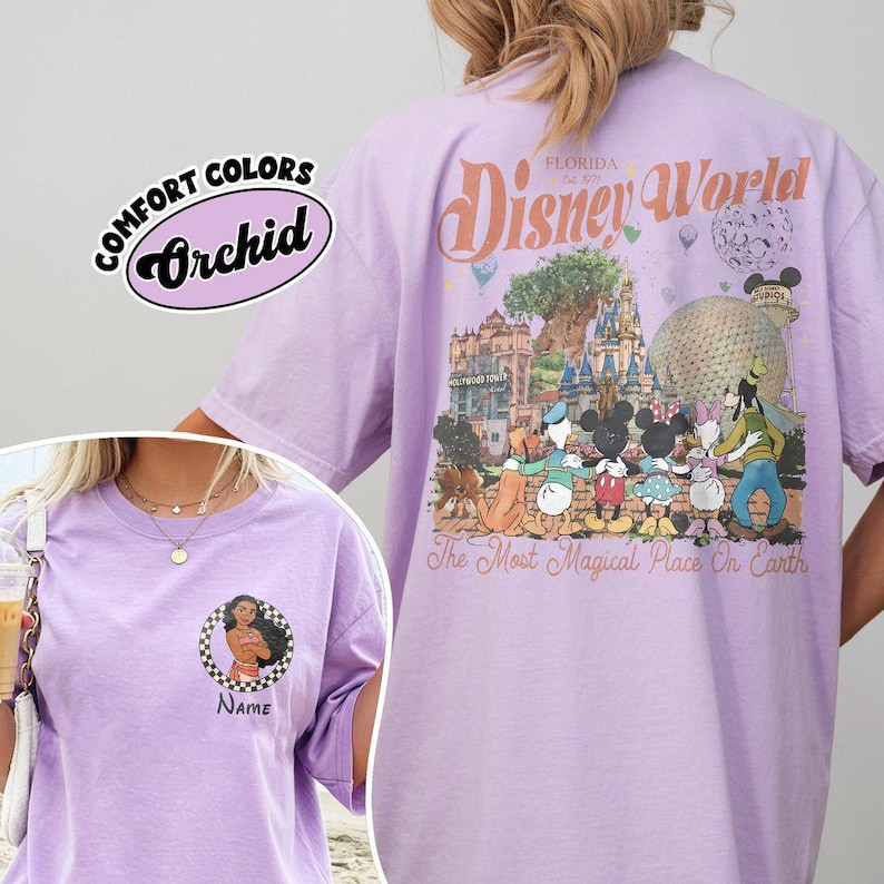 May include: A lilac t-shirt featuring a Disney World graphic on the back, with the text "Disney World Florida Est. 1971" and Disney characters. The front of the shirt has a small graphic with the text "Name".