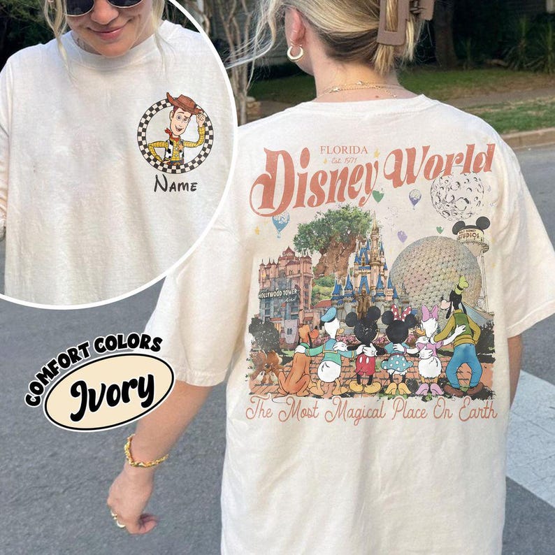 May include: Ivory long-sleeved t-shirt featuring a Woody cartoon on the front and a Disney World graphic on the back. The back graphic includes Disney characters and the text "Florida Disney World" and "The Most Magical Place On Earth."
