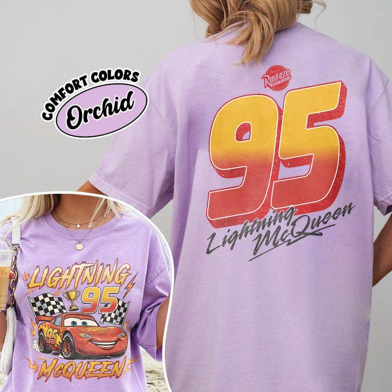 K&ouml;nnte beinhalten: Orchideenfarbenes T-Shirt mit einem Motiv aus dem Film Cars. Auf der Vorderseite sind Lightning McQueen, die Nummer 95 und die Worte "Lightning McQueen" abgebildet. Auf der R&uuml;ckseite steht gro&szlig; "95" und "Lightning McQueen".