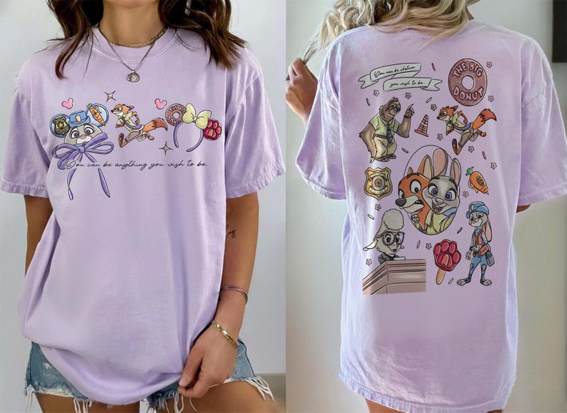 Puede incluir: Camiseta lila con personajes de dibujos animados y texto de Zootopia. La parte delantera muestra a Judy Hopps, Nick Wilde y accesorios tem&aacute;ticos. La parte trasera presenta m&aacute;s personajes y la frase "The Big Donut".