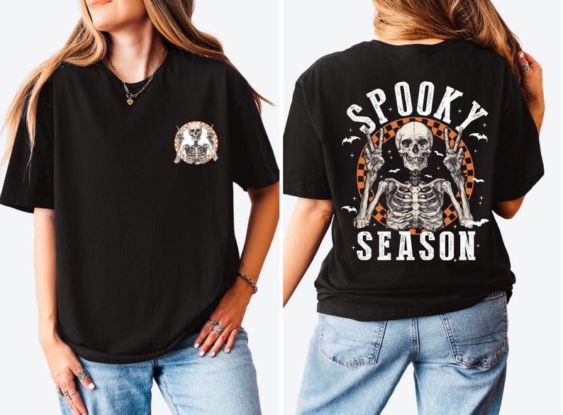 Puede incluir: Camiseta negra con un gr&aacute;fico de esqueleto. La parte delantera presenta un peque&ntilde;o dise&ntilde;o circular con dos esqueletos. La parte trasera muestra un dise&ntilde;o m&aacute;s grande con un esqueleto haciendo la se&ntilde;al de la paz, las palabras "Spooky Season" y murci&eacute;lagos.