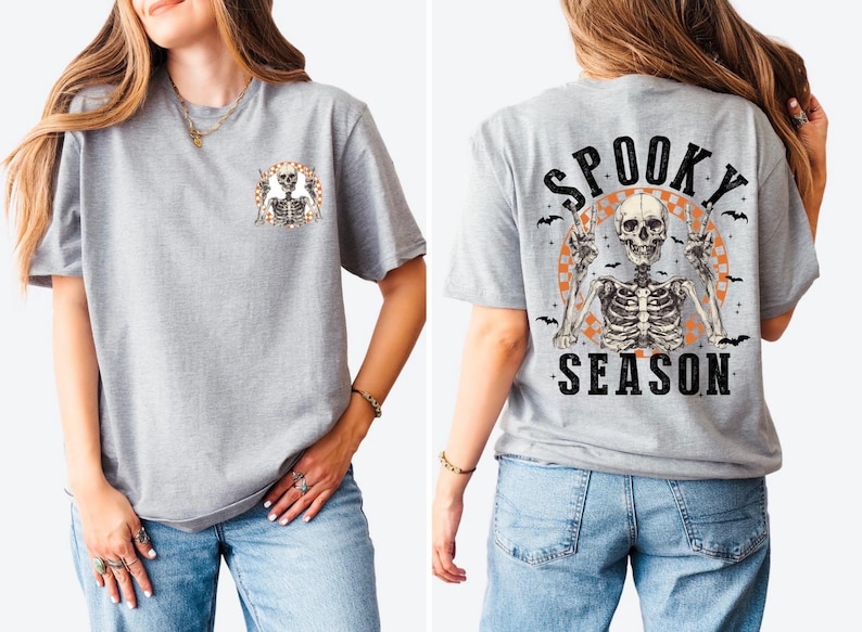 Puede incluir: Camiseta gris claro con un gr&aacute;fico de esqueleto. La parte delantera presenta un peque&ntilde;o dise&ntilde;o de esqueleto, mientras que la parte trasera muestra un esqueleto m&aacute;s grande con las palabras "Spooky Season" en negro. El dise&ntilde;o incluye acentos naranjas y negros.