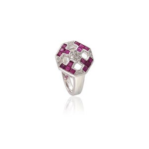 May include: A silver ring with a geometric design. The ring features a central octagonal shape with alternating squares of deep red gemstones and clear, sparkling stones. The band is a polished silver.