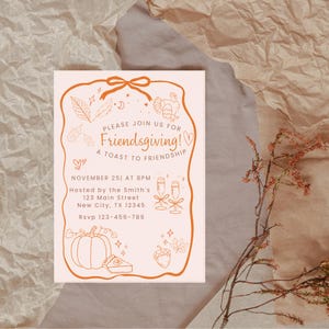Op de afbeelding: Een Friendsgiving-uitnodiging met een perzikkleurige achtergrond en oranje illustraties. De tekst luidt "Please join us for Friendsgiving! A Toast to Friendship" met datum, tijd en locatie. Decoratieve elementen zijn kalkoen, bladeren en champagneglazen.