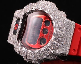 Könnte beinhalten: Eine rote Digitaluhr mit einer funkelnden, diamantbesetzten Lünette. Das Zifferblatt der Uhr ist rot mit einer Digitalanzeige, die die Uhrzeit anzeigt. Das Uhrenarmband ist rot. Die Uhr ist ein Luxusaccessoire.