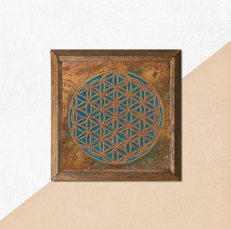 May include: Square wooden wall art featuring a teal and gold geometric design. The artwork has a circular pattern in the center, framed by a rustic brown wooden frame. The background has a textured, mottled appearance.