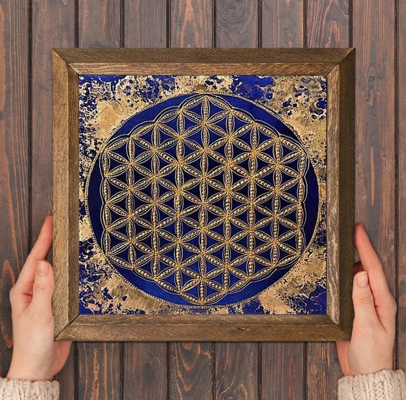 K&ouml;nnte beinhalten: Quadratische gerahmte Kunst mit einem goldenen und blauen Design. Das Kunstwerk hat eine dunkelblaue kreisf&ouml;rmige Mitte mit einem goldenen geometrischen Muster. Der Hintergrund hat ein goldenes und blaues strukturiertes Muster. Der Rahmen ist aus Holz.