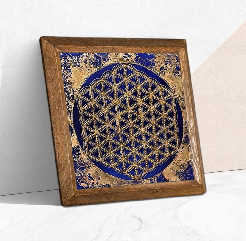 K&ouml;nnte beinhalten: Ein quadratisches Kunstwerk mit Holzrahmen. Es zeigt ein goldenes geometrisches Muster auf einem dunkelblauen Hintergrund, vor einem gold- und blau strukturierten Hintergrund. Der Rahmen besteht aus Naturholz.