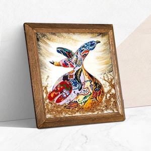 Może przedstawiać: Oprawione dzieło sztuki przedstawiające kolorowego wirującego derwisza. Postać zdobiona jest skomplikowanymi wzorami w kolorach czerwonym, niebieskim, żółtym i zielonym. Dzieło osadzone jest na złotym i białym tle, w drewnianej ramie.