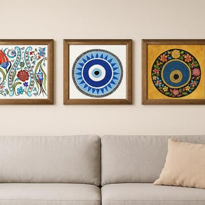 May include: Three framed wall art pieces with brown wooden frames. The art features floral and geometric designs in blue, red, yellow, and green. The artwork is displayed above a gray sofa with a beige pillow.