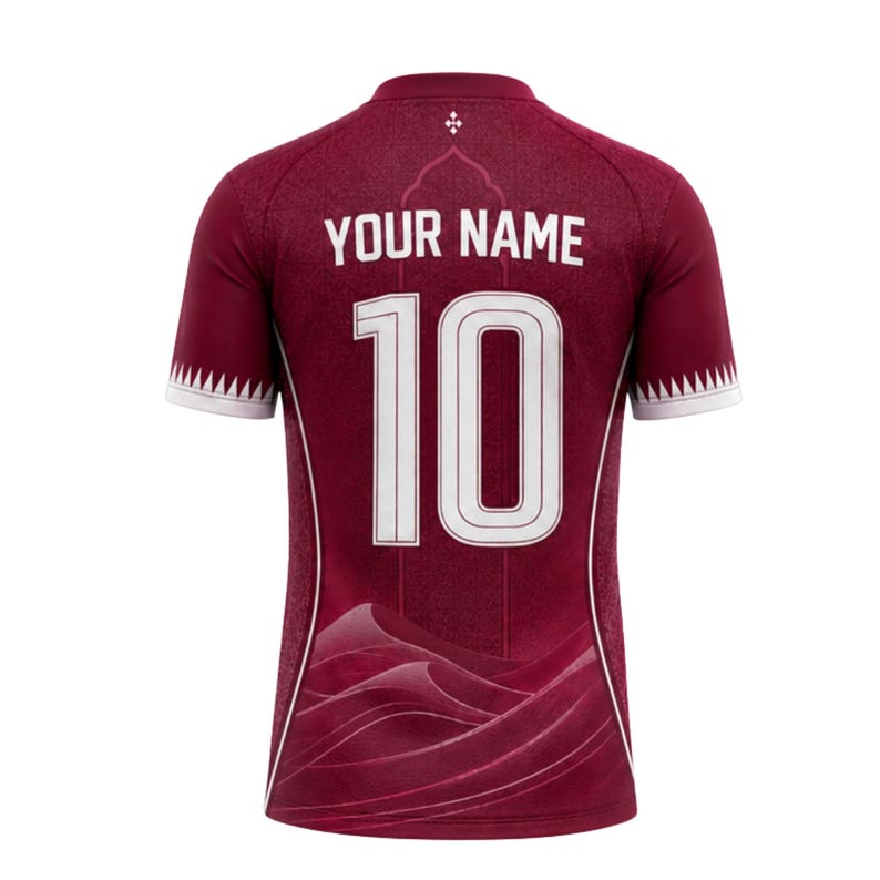 Puede incluir: Camiseta de f&uacute;tbol granate con detalles blancos, con el n&uacute;mero 10 y el texto "YOUR NAME" en blanco. La camiseta tiene un sutil patr&oacute;n de ondas y un peque&ntilde;o emblema cerca del cuello. Las mangas tienen un dise&ntilde;o blanco y granate.