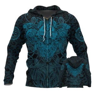 Peut inclure: Un sweat à capuche zippé à manches longues avec un imprimé graphique complexe inspiré de la mythologie nordique dans des tons noir et bleu sarcelle. Le motif présente une figure centrale barbue casquée entourée de volutes et de symboles.