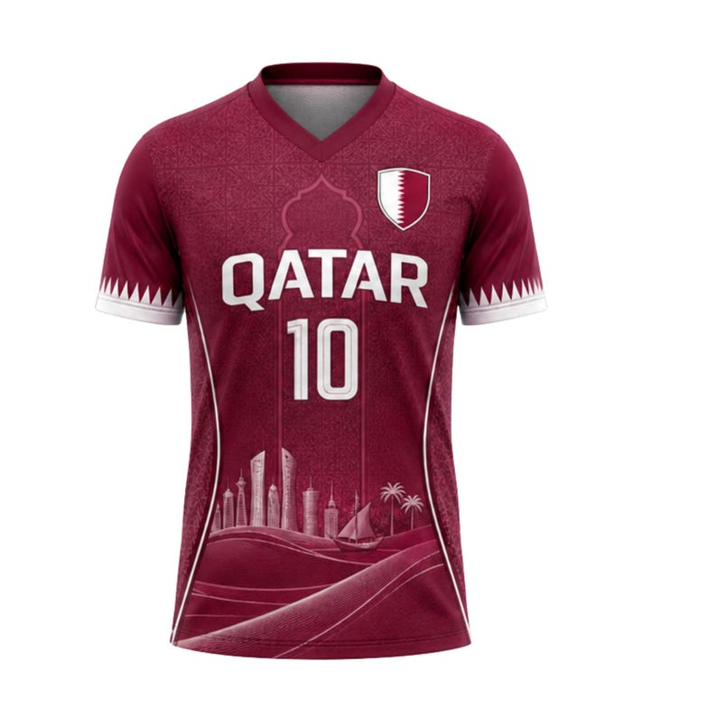 Puede incluir: Camiseta de f&uacute;tbol granate con detalles blancos. Muestra la palabra "QATAR" y el n&uacute;mero "10" en blanco. Incluye un gr&aacute;fico de horizonte y el emblema nacional de Qatar. Las mangas tienen ribetes blancos con dise&ntilde;o dentado.