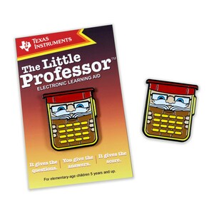 Könnte beinhalten: Eine rote, gelbe und braune Emaille-Anstecknadel mit einem Taschenrechner mit Gesicht, Brille und roter Mütze. Der Text "The Little Professor™ Electronic Learning Aid" befindet sich auf der Karte hinter der Anstecknadel.