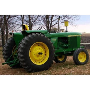 May include: A green John Deere tractor with large black tyres and yellow rims. The tractor has a yellow seat and the model number 5020 is visible on the side. The tractor is parked on a grassy area with trees in the background.