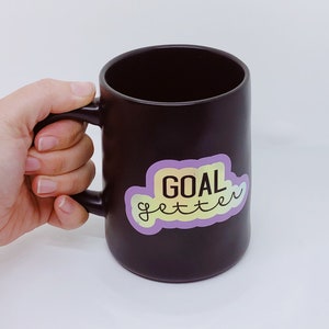 Taza de té de café inspiradora de Goal Getter - Negro