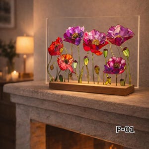 Può includere: Un'opera d'arte floreale decorativa con fiori di papavero colorati nei toni del rosso, rosa e viola. I fiori sono inseriti in un pannello di acrilico trasparente e montati su una base di legno. L'opera è etichettata "P-01".