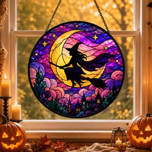 May include: A circular stained glass suncatcher featuring a silhouette of a witch flying on a broomstick against a large yellow crescent moon. The background displays a purple and blue night sky with stars above a dark landscape of castle towers.