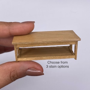 Może przedstawiać: Miniaturowy drewniany stolik kawowy z dolną półką. Stół jest jasnobrązowy i ma prostokątny blat. Widoczny jest tekst "Choose from 3 stain options".