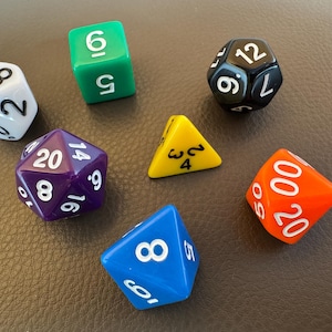May include: A collection of colorful polyhedral dice for tabletop games. The dice are various shapes and colors, including white, green, black, purple, yellow, blue, and orange. Each die has white numbers.