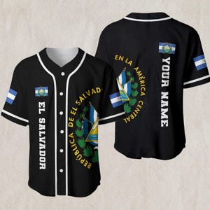 Könnte beinhalten: Schwarzes Baseball-Trikot mit weißen Zierleisten und Knöpfen. Mit dem Wappen und der Flagge von El Salvador, mit dem Text "EL SALVADOR" und "REPUBLICA DE EL SALVADOR". Auf der Rückseite steht vertikal "YOUR NAME".