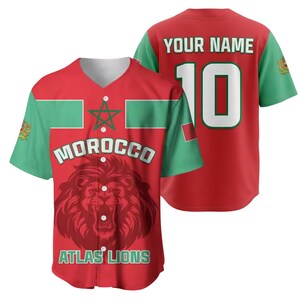 May include: Red baseball jersey with green sleeves and accents. The front features the word "MOROCCO" above a lion graphic and the text "ATLAS LIONS". The back displays "YOUR NAME" and the number "10".