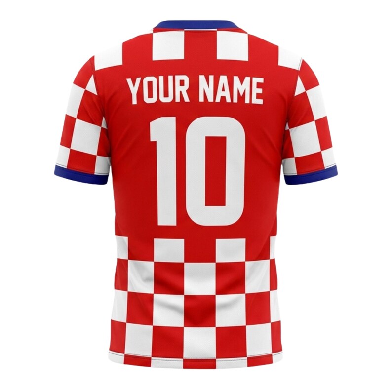 May include: Red soccer jersey with white checkered pattern on the shoulders and lower section. The jersey features the number 10 in white and the text "YOUR NAME" above it. The collar and sleeve cuffs are blue.