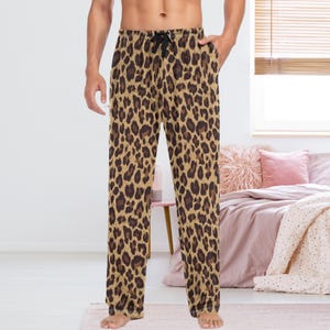 May include: Tan and brown leopard print pajama pants with a drawstring waist and pockets. The pants are made of a soft material and are designed for comfort. The animal print pattern is a classic and stylish design.