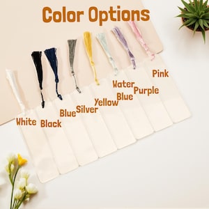 May include: A selection of bookmarks with colorful tassels. The image displays bookmarks with tassels in white, black, blue, silver, yellow, water blue, purple, and pink. The text "Color Options" is at the top.