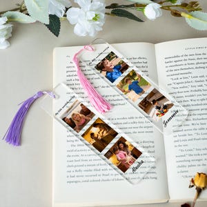 May include: Clear acrylic bookmarks with family photos and colorful tassels. One bookmark has a pink tassel, the other a purple tassel. The bookmarks are on top of an open book.